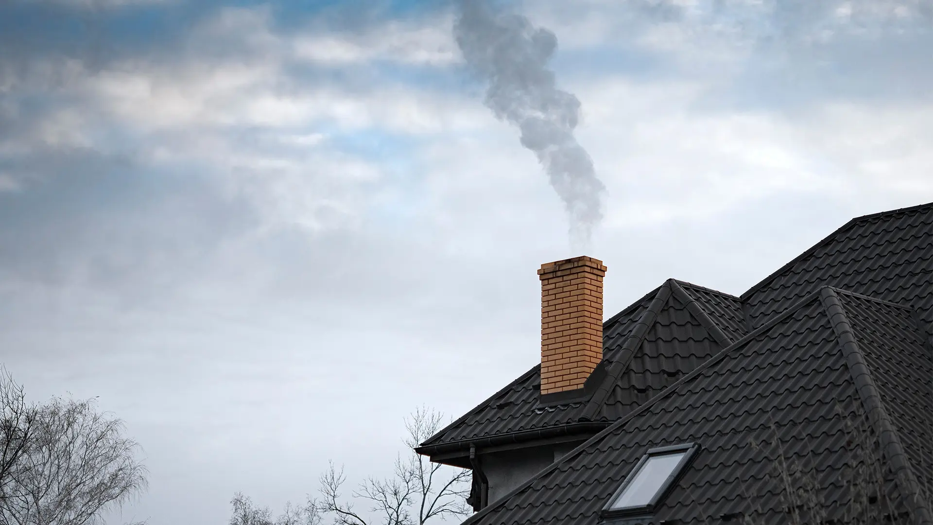 Chimney smoke rising over a Grand County rooftop