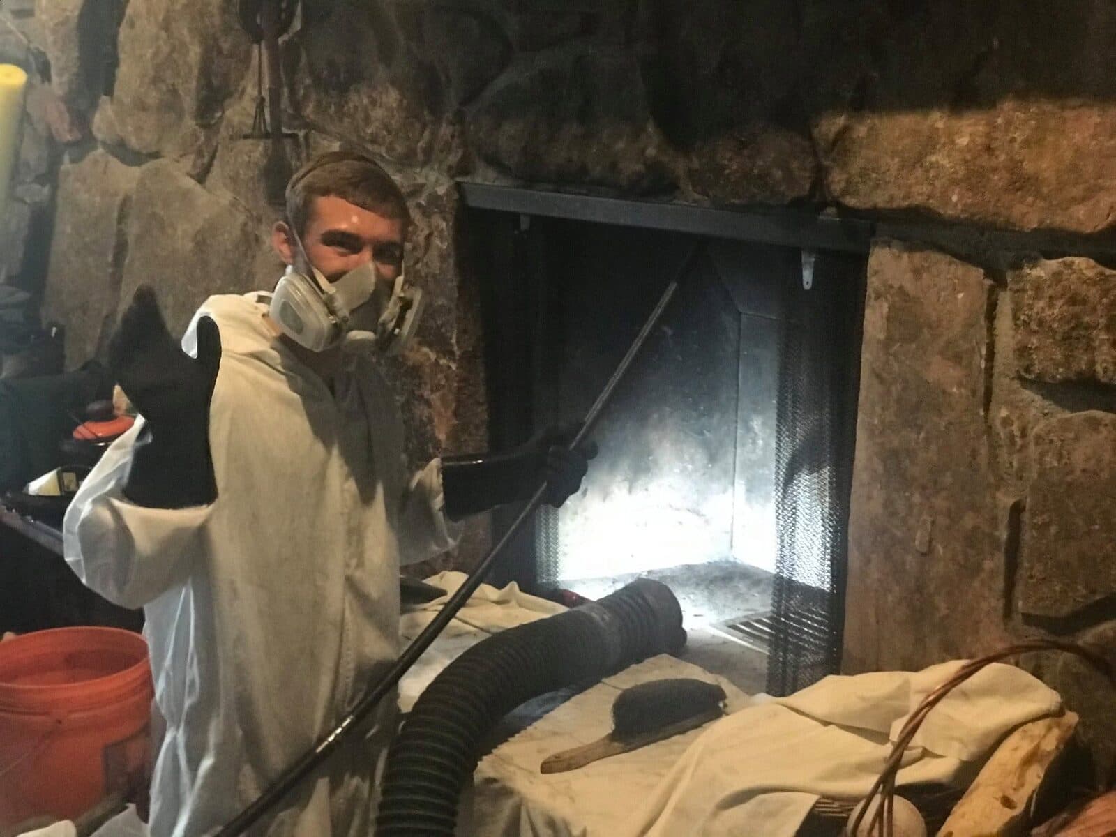 Worker in respirator servicing a vent in a crawl space
